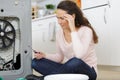 Female trying to fix washing machine Royalty Free Stock Photo