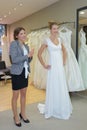 Female trying on wedding dress in shop with assistant Royalty Free Stock Photo