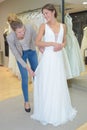 Female trying wedding dress in shop with women assistant Royalty Free Stock Photo