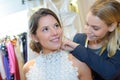 Female trying wedding dress in shop with women assistant Royalty Free Stock Photo