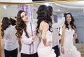 Female trying on wedding dress in a shop with women assistant. Royalty Free Stock Photo