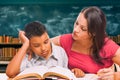 Female Tutor Doing Homework with a Young Hispanic Boy in the Classroom Royalty Free Stock Photo
