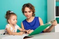 Female tutor with little girl doing homework. Preschool concept.