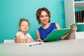 Female tutor with little girl doing homework. Preschool concept.