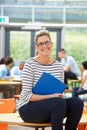 Female Tutor Sitting In Classroom With Folder Royalty Free Stock Photo