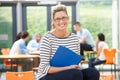 Female Tutor Sitting In Classroom With Folder Royalty Free Stock Photo