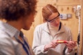 Female Tutor With Trainee Electrician In Workshop Studying For Apprenticeship At College Royalty Free Stock Photo