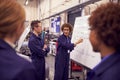 Female Tutor By Whiteboard With Students Teaching Auto Mechanic Apprenticeship At College