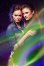 Female twins in colored light stripes. Royalty Free Stock Photo