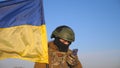 Female ukrainian army soldier using smartphone to read news or messaging with family. Girl in military uniform and