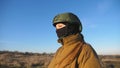 Female ukrainian army soldier walking at the field. Woman in military uniform and helmet going on meadow at sunset