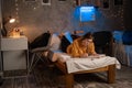 Female university or college student studying with textbooks on bed in dorm room. Night life of student.