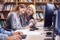 Female University Or College Student Working At Computer In Library Being Helped By Tutor Royalty Free Stock Photo