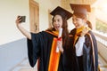 Female university graduates celebrate happily after completed and received diploma degree certificate in commencement ceremony. Th Royalty Free Stock Photo