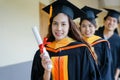 Female university graduates celebrate happily after completed and received diploma degree certificate in commencement ceremony. Th Royalty Free Stock Photo