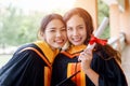 Female university graduates celebrate happily after completed and received diploma degree certificate in commencement ceremony. Th Royalty Free Stock Photo