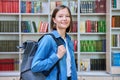 Female university student with backpack, inside library of educational building Royalty Free Stock Photo