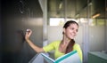 Female university student in front of a blackboard solving a problem Royalty Free Stock Photo