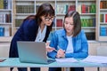 Female university student with teacher preparing for exam, inside library Royalty Free Stock Photo