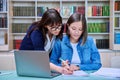 Female university student with teacher preparing for exam, inside library Royalty Free Stock Photo