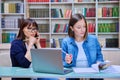 Female university student with teacher preparing for exam, inside library Royalty Free Stock Photo