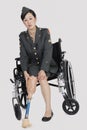 Female US military officer in wheelchair holding artificial limb over gray backgrounds