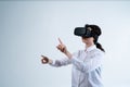 Woman using virtual reality headset and interacting with virtual interface using both hands in clean white studio background Royalty Free Stock Photo