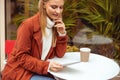 Female using her phone in a street cafe Royalty Free Stock Photo