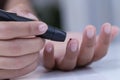 Female using lancelet on finger, Diabetic checking blood sugar levels