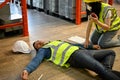 A female using a walkie-talkie called the factory`s first aid team to rescue an unconscious man Royalty Free Stock Photo