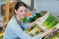 female vegetable vendor taking out leek container