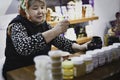 Female vendor selling honey and spices at a marketplace in Doha