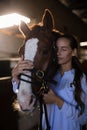 Female vet with eyes closed standing by horse at stable Royalty Free Stock Photo