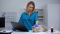 Female veterinarian sadly looking at cat holding x-ray, terminally ill pet Royalty Free Stock Photo