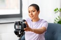 Female video blogger adjusting camera at home