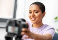 Female video blogger adjusting camera at home