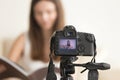 Female video blogger recording vlog on DSLR camera