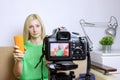 Female video blogger recording vlog or podcast, streaming online. Blurred camera on tripod in front. Royalty Free Stock Photo