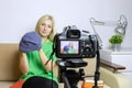 Female video blogger recording vlog or podcast, streaming online. Blurred camera on tripod in front. Royalty Free Stock Photo