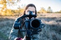 Female videographer holding a gimbal with mirrorless camera. Woman with stabilized camera rig filming outdoors on a sunny