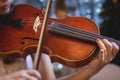 Female violin player, fiddler violinist with a bow performing music on stage during concert with orchestra and musical band in the Royalty Free Stock Photo