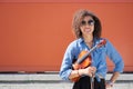 Female violinist with violin under arm smiling at camera
