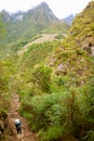 Female visitor shooting photos of Machu Picchu Incas citadel ruins from the slope of Mt. Huayna Picchu, Peru Royalty Free Stock Photo