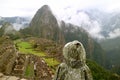 Female visitor wearing raincoat full of raindrops Looking at the Machu Picchu Inca citadel in light rain, Cusco, Peru