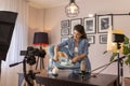 Female vlogger recording video about use of newborn baby rocking chair Royalty Free Stock Photo