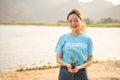 Female Volunteer carrying a seedlings to be planted into the soil in the river as save world concept, nature, environment and