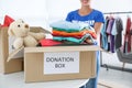 Female volunteer collecting donations at table indoors