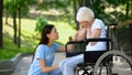 Female volunteer comforting crying old lady wheelchair, old age disability, help