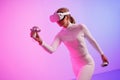 Female in VR glasses workout by illuminated neon room