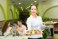 Female waiter serving guests table